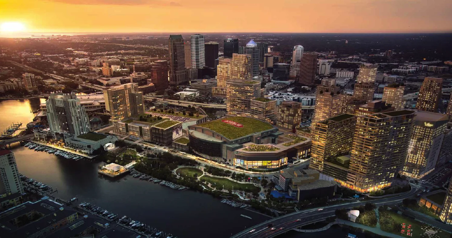 Aerial rendering of Water Street Tampa at sunset: new towers around Amalie Arena, the channel and marina in the foreground