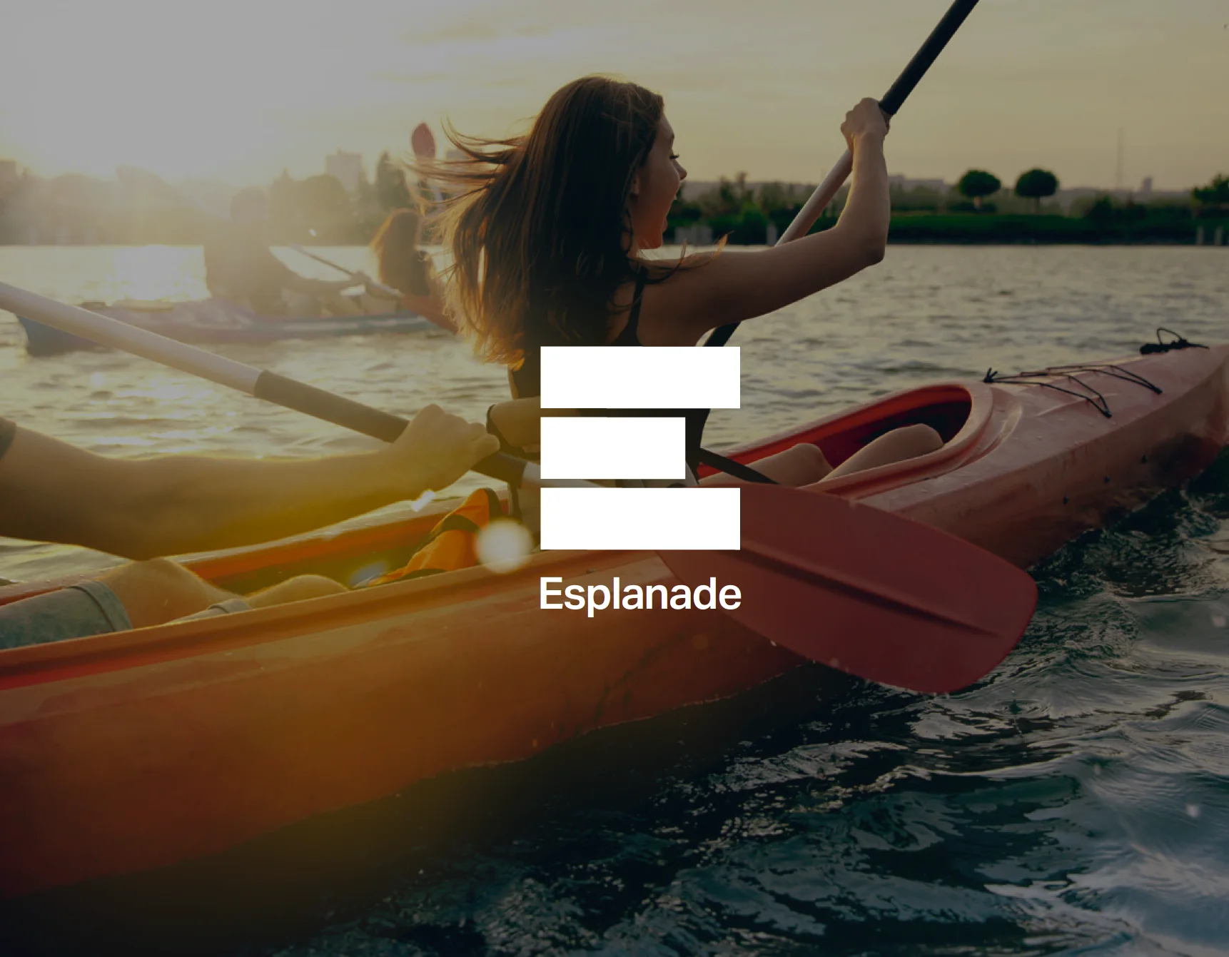The Esplanade E monogram over a photo of kayakers on the river at sunset
