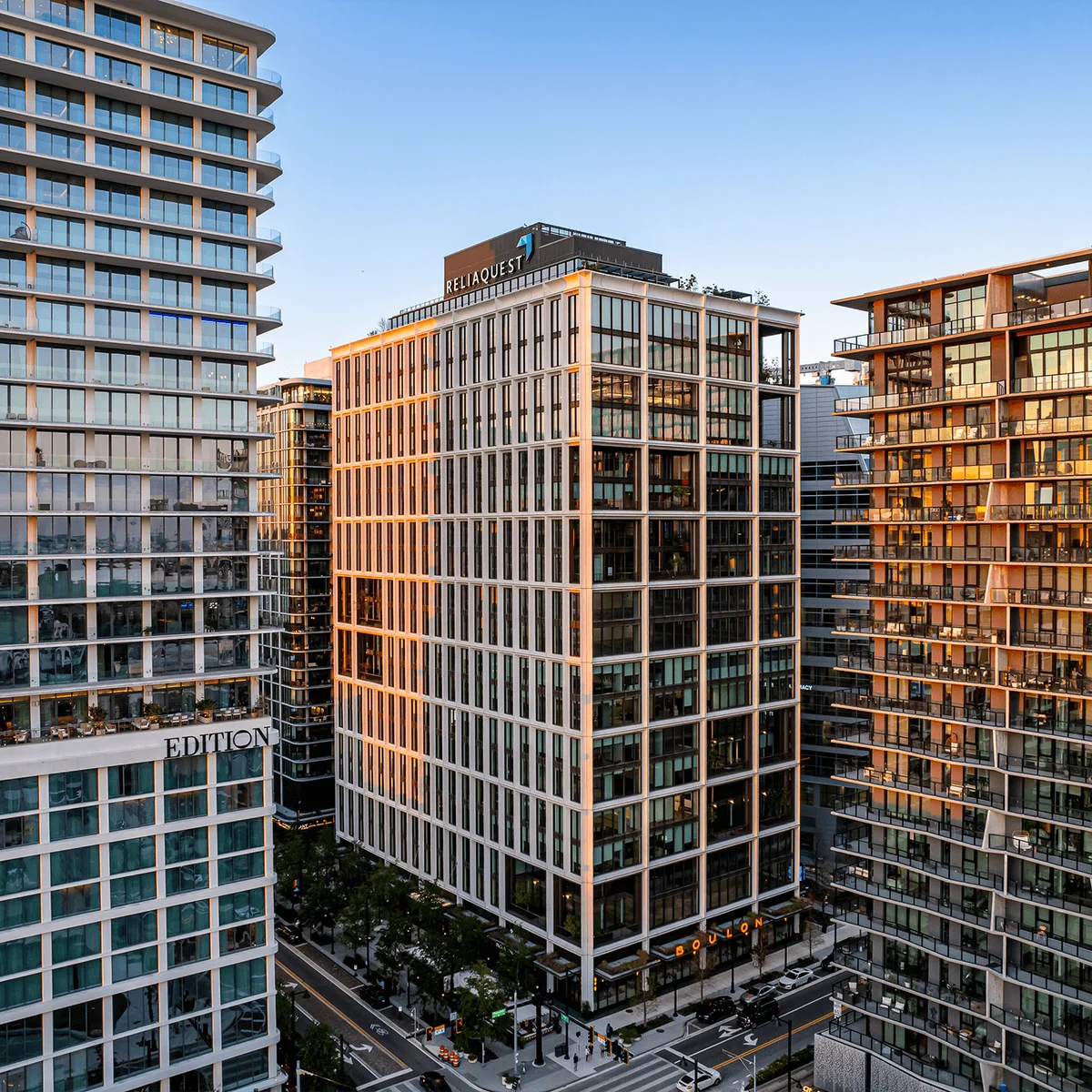 Photograph of Thousand & One, the COOKFOX-designed tower at 1001 Water Street, at golden hour between the EDITION hotel and a residential tower