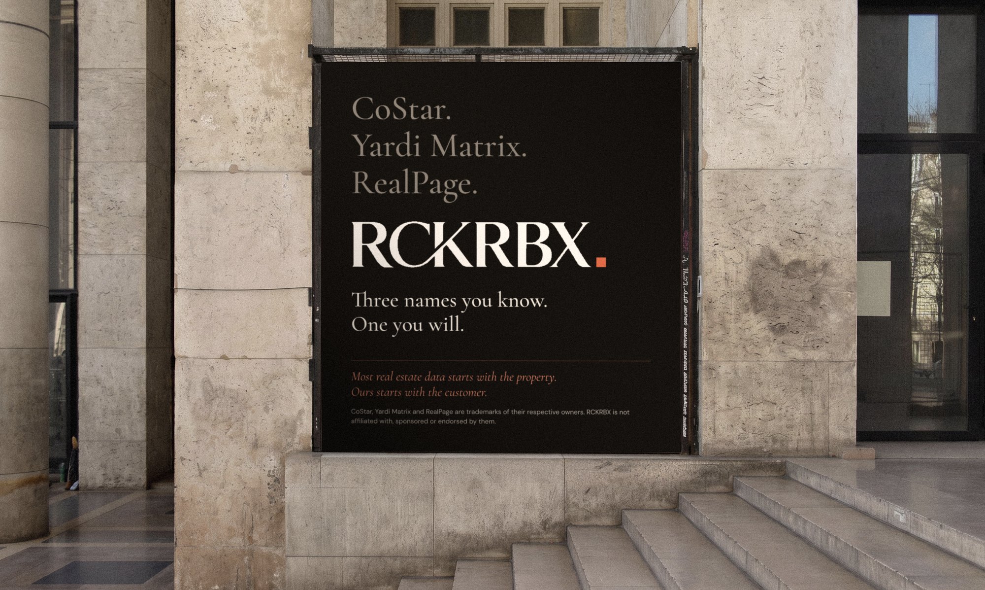 A dark poster in a stone portico: CoStar, Yardi Matrix, RealPage, then the RCKRBX wordmark and the line Three names you know. One you will.