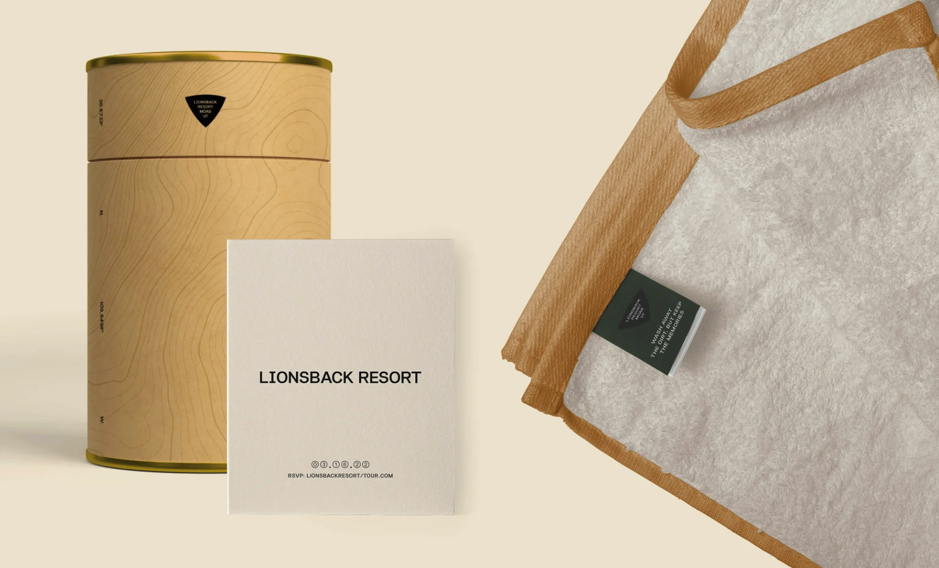 Welcome kit: a kraft tube printed with contour lines and the badge, an invitation card, and a towel with a green tag reading Wash away the dirt, but keep the memories